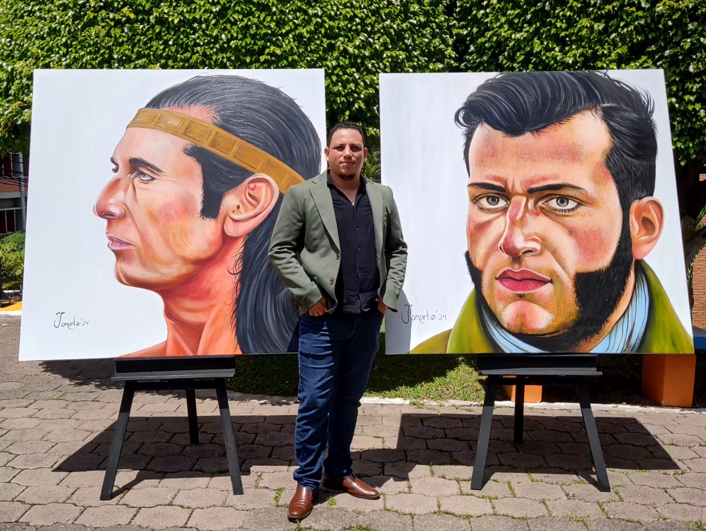 Jonarte junto a los retratos al óleo del Indio Lempira y Francisco Morazán