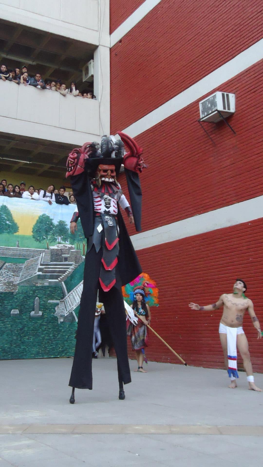 Representación al aire libre con personajes en zancos